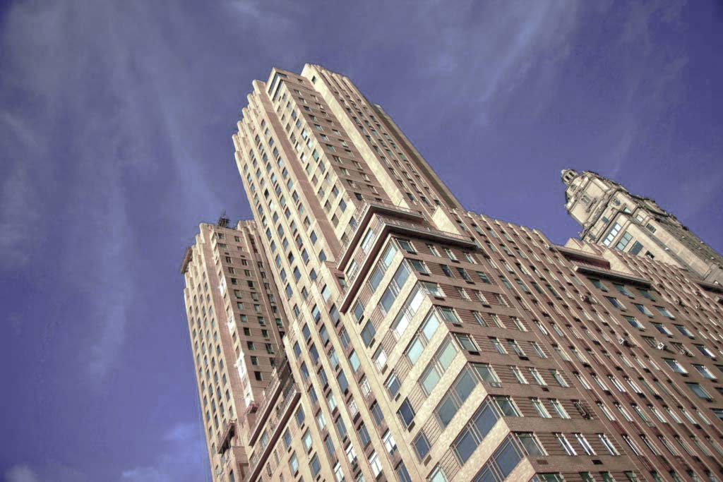 A tall building with many windows and a sky background